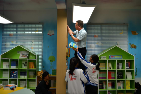 ▲于都县岭背镇中心小学老师和同学们一起布置新的阅读室。陈逸航 摄